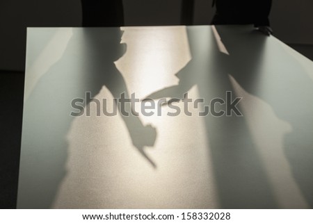 Shadow of two business people arguing and gesturing on the floor of the office