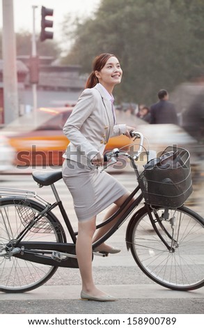 Young business woman commuting with a bicycle in Beijing