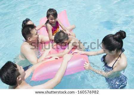 Family and friends playing in water at the pool