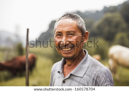 Portrait of smiling farmer with livestock in background