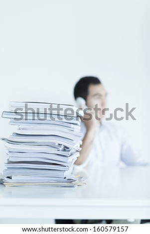 Businessman on the with stack of papers on desk
