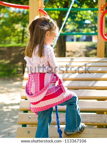 Cute little girl on playground equipment