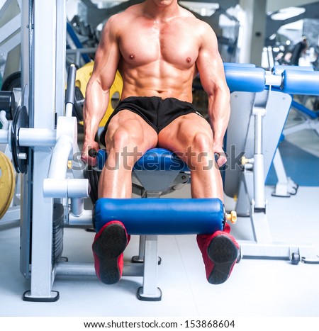 strong sportsman doing leg exercises at the gym