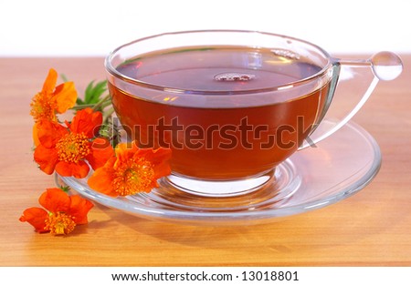 Tea in a transparent cup and flowers