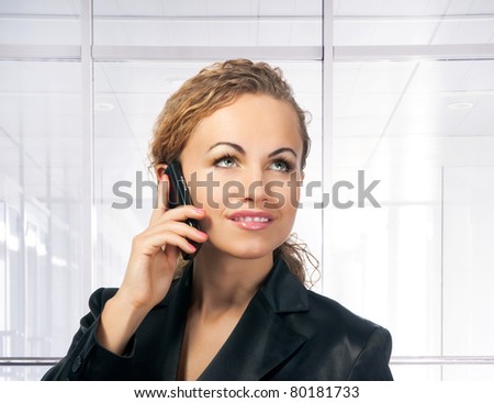 Young woman on phone. Office build background