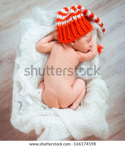 Cute newborn baby sleeps in a santa claus hat