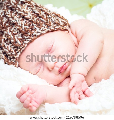 beautiful newborn baby boy sleeping in knitted cap close-up