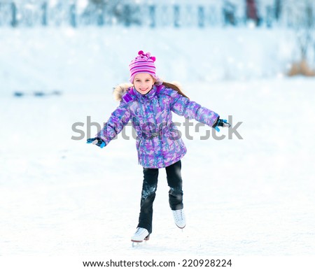 Happy l little girl skating in winter outdoors