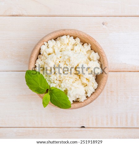cottage cheese in a wooden bowl on a wooden background