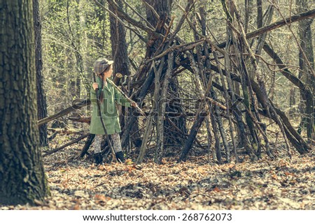 little girl in the wood near the hut. back view.  Photo in retro style