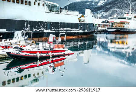 The ships and boats on the mooring in the Norwegian fjords in the winter