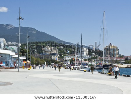 YALTA, CRIMEA - MAY 11: unidentified people on sea quay, yachts in port, hills and hotels on shore. Yalta is a best resort on Black sea called \