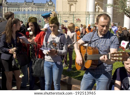 MOSCOW - MAY 9, 2014: Holiday Victory Day devoted to victory in Second World War, people sing war songs on the street near Big Theatre.
