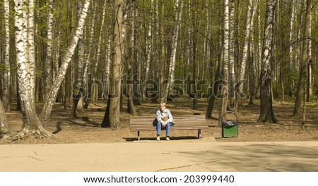 MOSCOW - APRIL 29, 2014: woman rests in Izmaylovskiy park in summer. The biggest park of Europe with territory 1500 hectare exist on basis of former king estate from 16 century