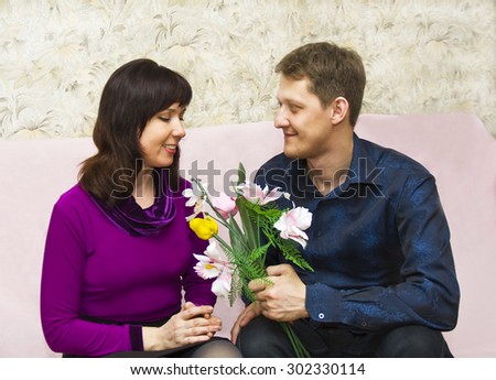 Young couple European on dating, man presents bouquet flowers to woman.