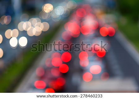 Defocused vehicles stuck in the traffic jam on the highway in the city.
