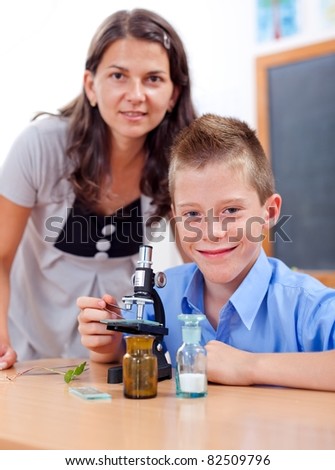 Wise boy with microscope and the biology teacher