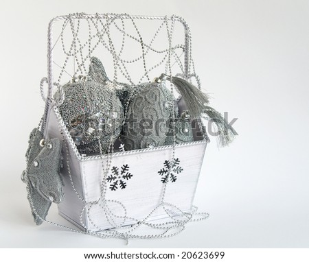 Box with silver christmas decoration on white background