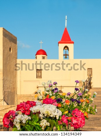 St. John church in Acre (Akko) Israel on sunset with vibrant flowers on the forteground