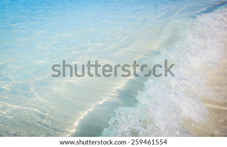 The sea water wave hit the sandy beach on uninhabited island Half Moon Cay (The Bahamas).
