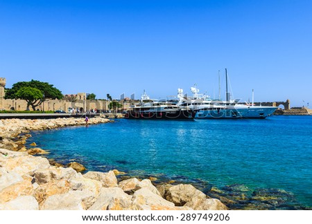 RHODOS, GREECE- JUNE 15: Luxury yachts and other boats docked at port of Rhodes on a beautiful sunny day at Rhodes island, Greece on June 15, 2015.
