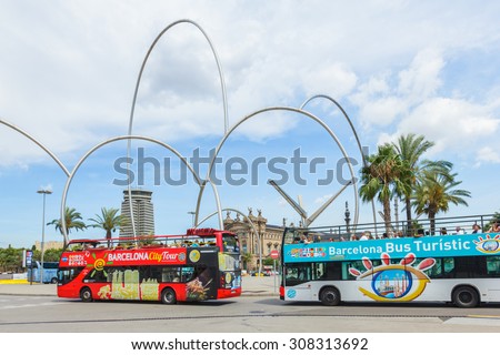 BARCELONA, SPAIN- AUGUST 13: Hop on- Hop off buses transfer tourists around tourist attractions in Barcelona city, Spain on August 13, 2015.