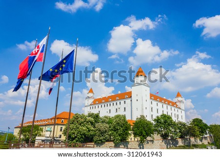 BRATISLAVA, SLOVAKIA- MAY 1: Bratislava castle and flags on bright sunny day on May 1, 2014. The massive rectangular building with four corner towers stands on a rocky hill in capital of Slovakia.