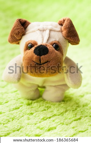 Plush puppy on green blanket.