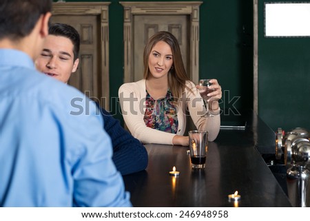 Young woman sitting at the bar alone and flirting.