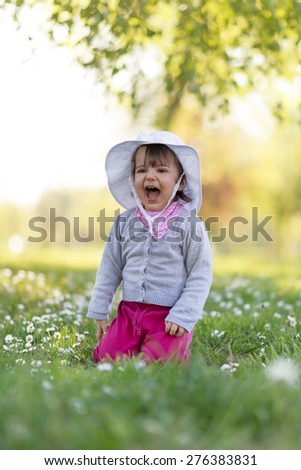 Cute little girl playing in the park on spring day... Selective focus, shallow deep of field, focus is in the eye of baby...