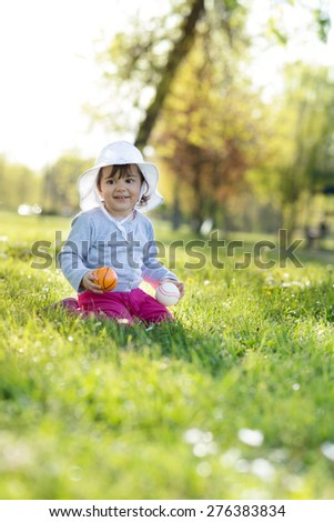 Cute little girl playing in the park on spring day... Selective focus, shallow deep of field, focus is in the eye of baby...