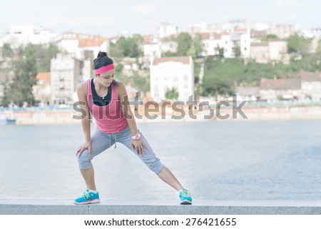Woman doing  warm-up exercises before running.Photo is carefully post processed to mach old Kodak  film look.
