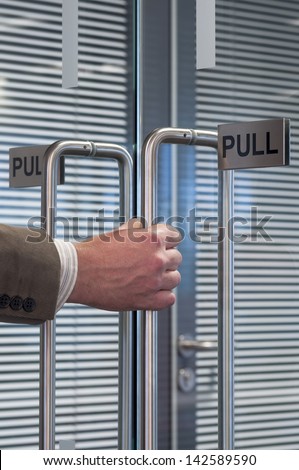 close up of a hand pulling open an office door