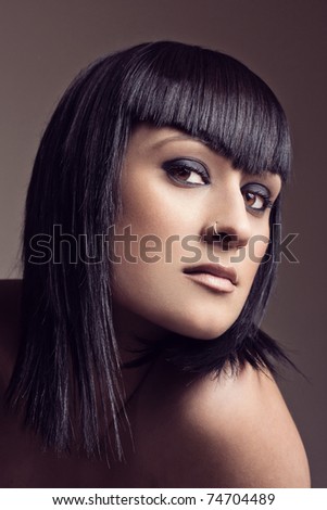 Portrait of a beautiful sexy woman with a piercing on the nose looking at camera