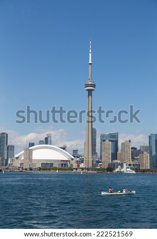 TORONTO, CANADA - 27TH JULY 2014: The CN Tower and Rogers Centre from Lake Ontario during the day with people in a canoe in the foreground