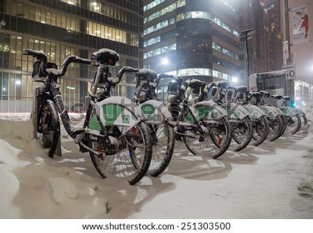 TORONTO, CANADA - 7TH FEBRUARY 2015: Toronto Bike Share bikes in at night with snow on them