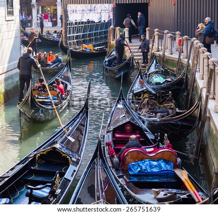 VENICE, ITALY - 15TH MARCH 2015: Large amounts of gondolas in Venice during the day. People can be seen