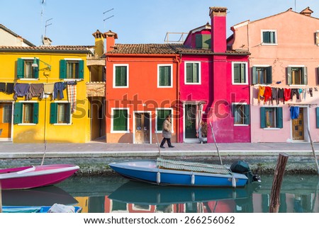 BURANO, ITALY - 14TH MARCH 2015: Colourful buildings in Burano during the day. A man can be seen walking outside