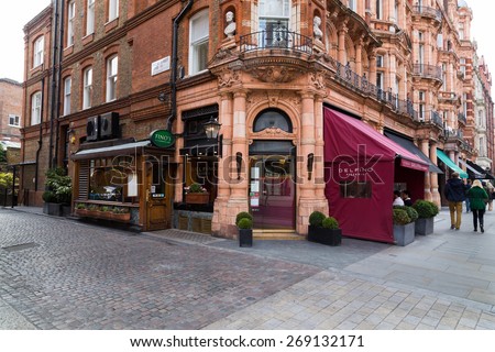 LONDON, UK - 27TH MARCH 2015:  The outside of Delfino Pizzeria Restaurant in Mayfair London during the day. People can be seen on the restaurant Patio