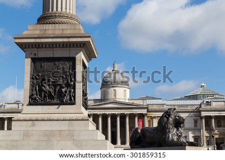 LONDON, UK - 21ST JULY 2015: Part of Nelsons Column, The National Gallery and a Lion Monument at Trafalgar Square in London during the day.