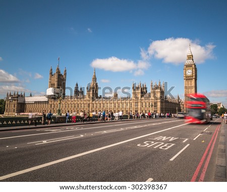LONDON, UK - 21ST JULY 2015: Big Ben in Westminster with red London Buses. Lots of people can be seen.