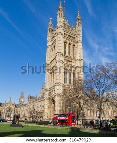 LONDON, UK - 10TH MARCH 2015: A view of the Victoria Tower in London. People and a London Bus can be seen near the base of the building.