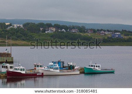 INVERNESS, CANADA - 6TH JULY 2015: Boats docked at a harbour in Inverness in Cape Breton Canada. Buildings can be seen in the distance.