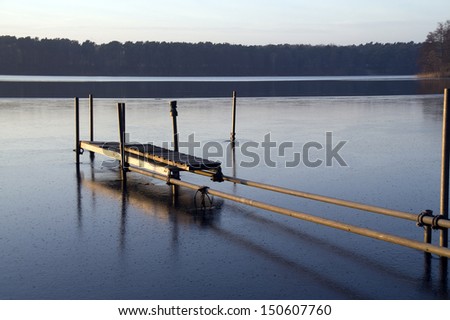oblique in wooden Jetty protruding into a lake in evening mood