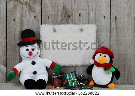 Blank sign with holiday decorations and snowman on wooden fence