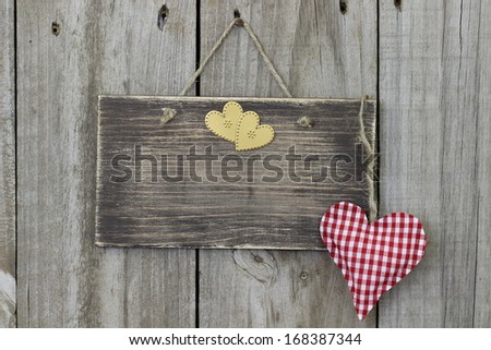 Blank wood sign hanging on door with gingham and gold hearts