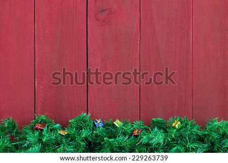 Green pine tree garland Christmas border with presents border antique red wooden background