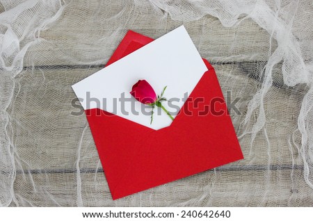 Blank white love letter or note card with red rose on shabby white netting background