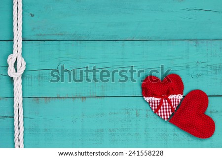 Red hearts border and white rope with knot on blank antique teal blue old weathered background