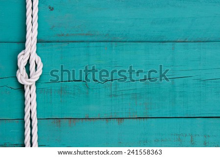 White rope with knot on blank  antique teal blue rustic wooden background